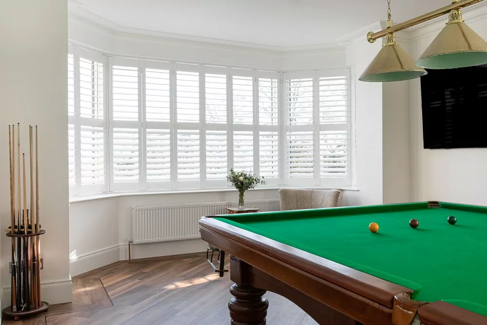 plantation shutters in large bay window with pool table