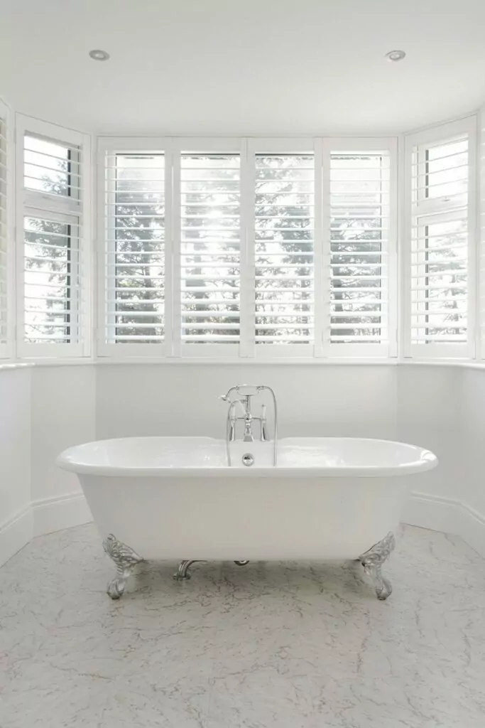 plantation shutters project in white bathroom with stand alone bath