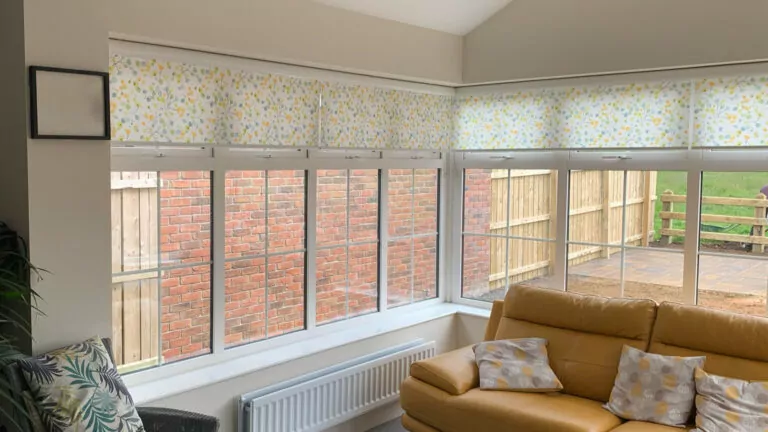 a conservatory with roller blinds on all the windows