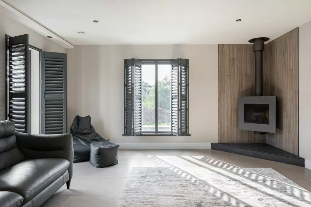 Basalt Grey Painted Plantation Shutters in Living Room with fireplace - Village Blinds and Shutters Northern Ireland