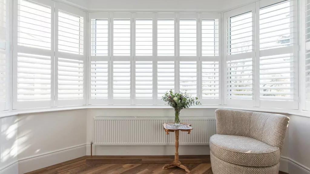 Beautiful White Plantation Shutters in a Bay Window made by a local shutter company