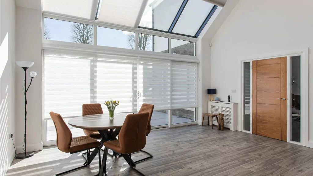Modern home showing benefits of Self Build home with white aura day night blinds cellular roof window blinds in a spacious dining room