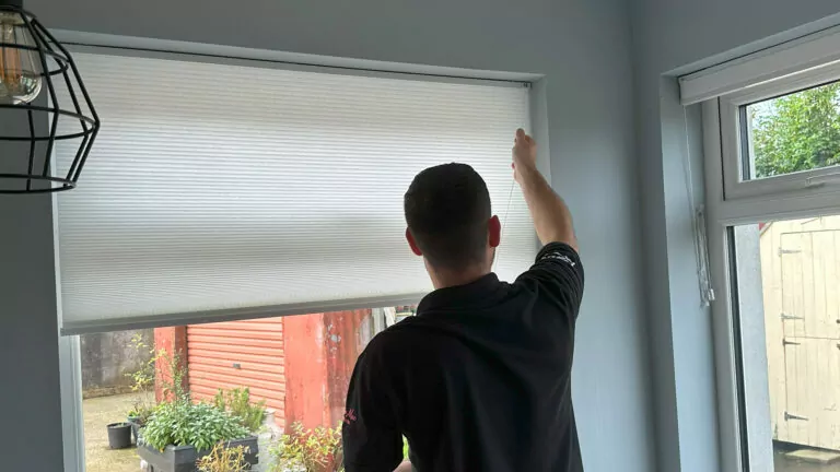 a grey roller fitted blind being installed by a professional