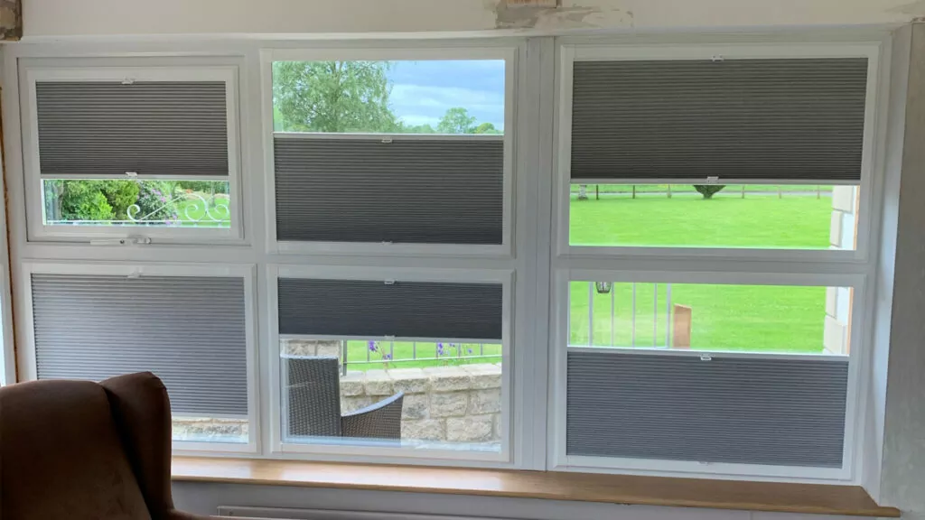 grey cellular perfect fit blinds with white frames fitted onto windows