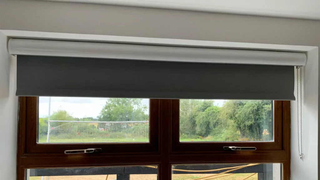 a grey roller fitted blind inside the recess of the window