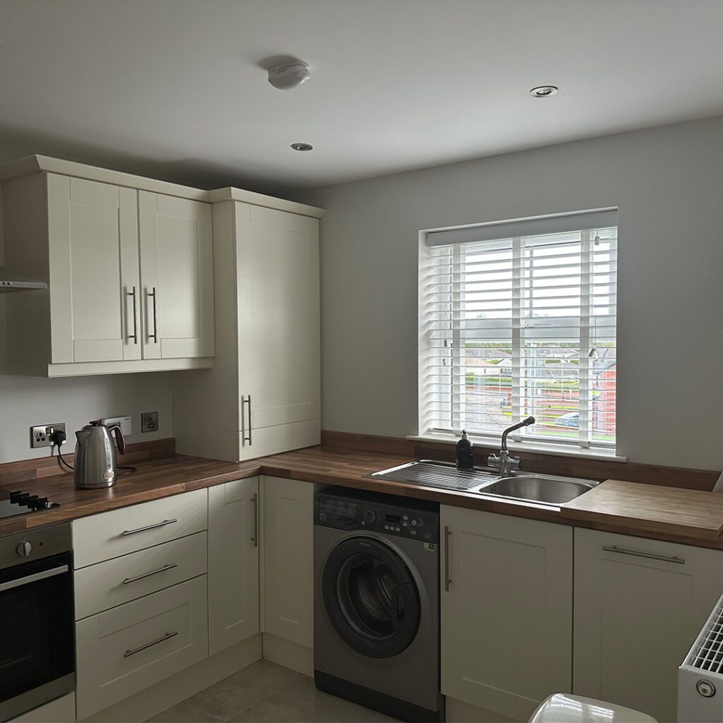 White Wooden Blind with tilted slats providing light and privacy to a modern kitchen in Northern Ireland
